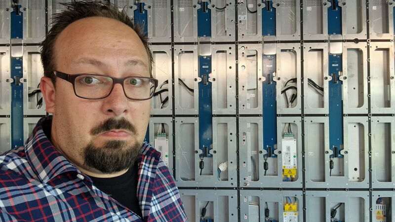 Julian Klietz steht vor einem noch nicht fertig montierten LED-Screen.