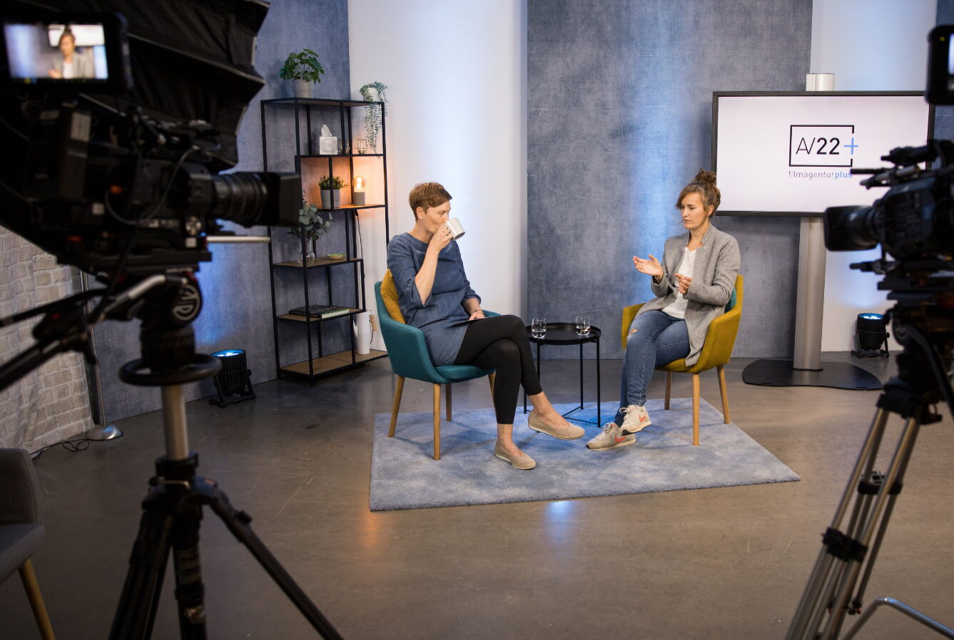 AV22 studio – Johanna und Franka sitzen in einem Videostudio in professioneller Studioumgebung