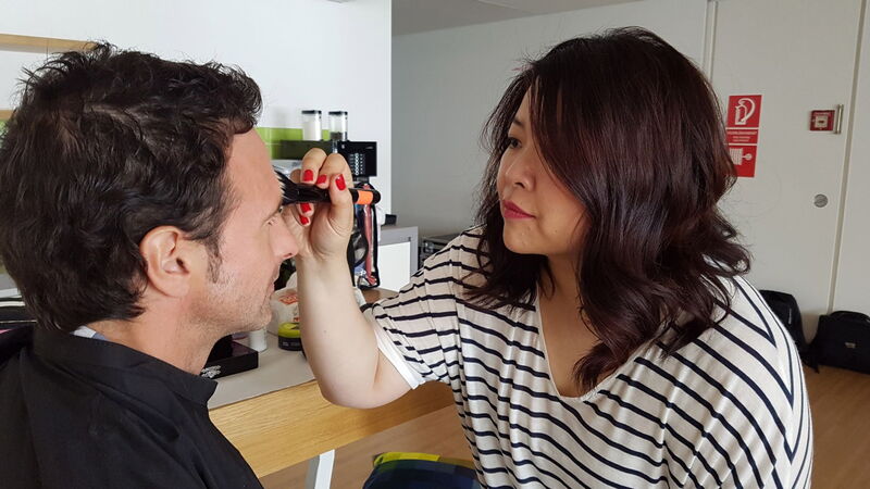 Maskenbildnerin Bigshan Choi macht Moderator Immo Mäueler schön.