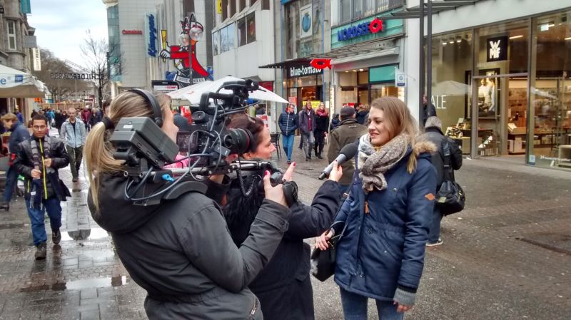 Kamerafrau Tina und Redakteurin Anja interviewen eine Passantin in der Kölner Innenstadt.