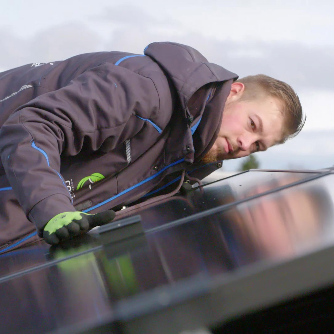 AV22 film – Mitarbeiter montiert Solarmodule auf einem Dach