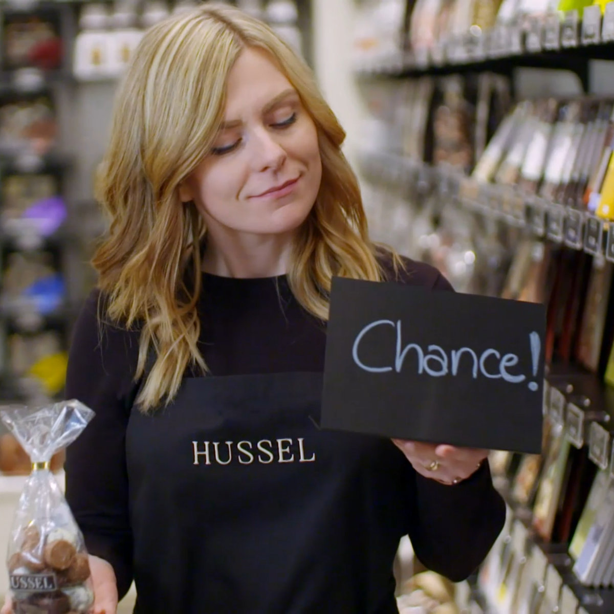 AV22 film – Eine Frau hält ein Schild mit dem Wort „Chance“ in die Kamera