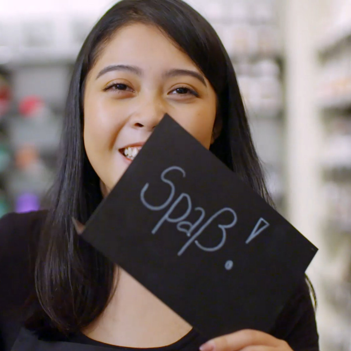 AV22 film – Eine Frau präsentiert ein Schild mit dem Wort „Spaß“