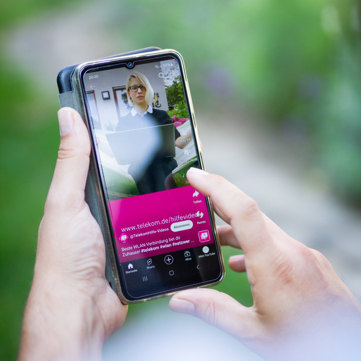 AV22 film – Eine Hand hält ein Smartphone mit laufendem Social-Media-Video