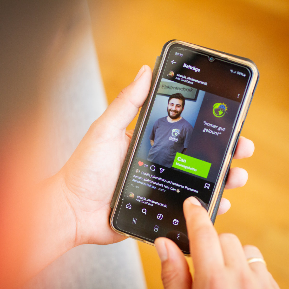 AV22 online – Person hält Smartphone mit sichtbaren Social-Media-Inhalten